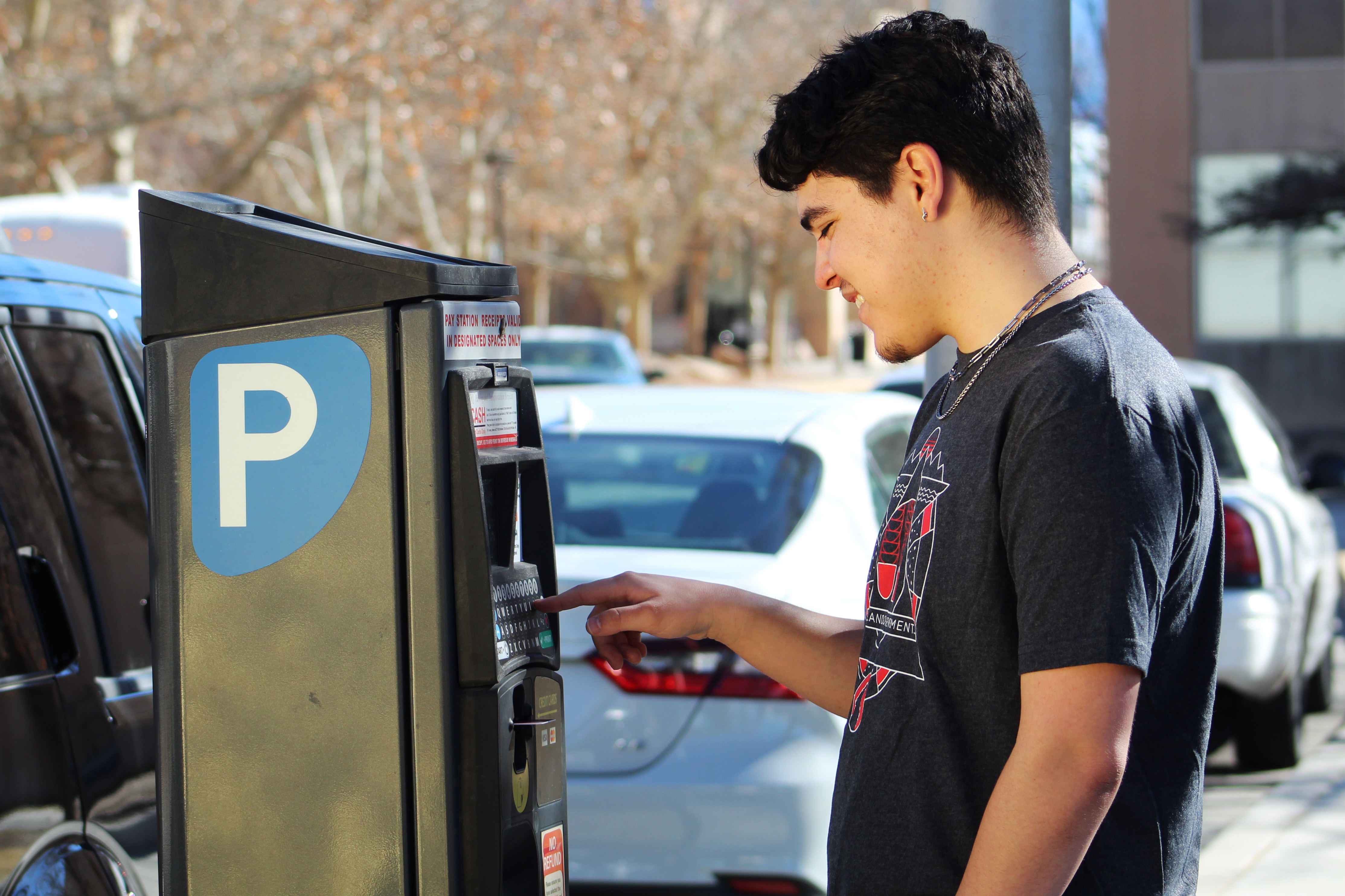 Male presenting student using pay station